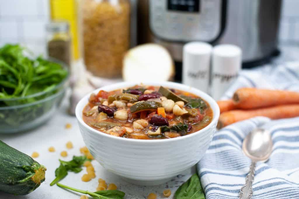 bowl of minestrone soup and instant pot with vegetables