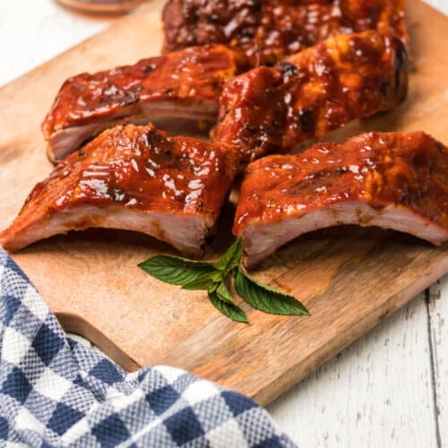bbq ribs on a cutting board with blue check napkin