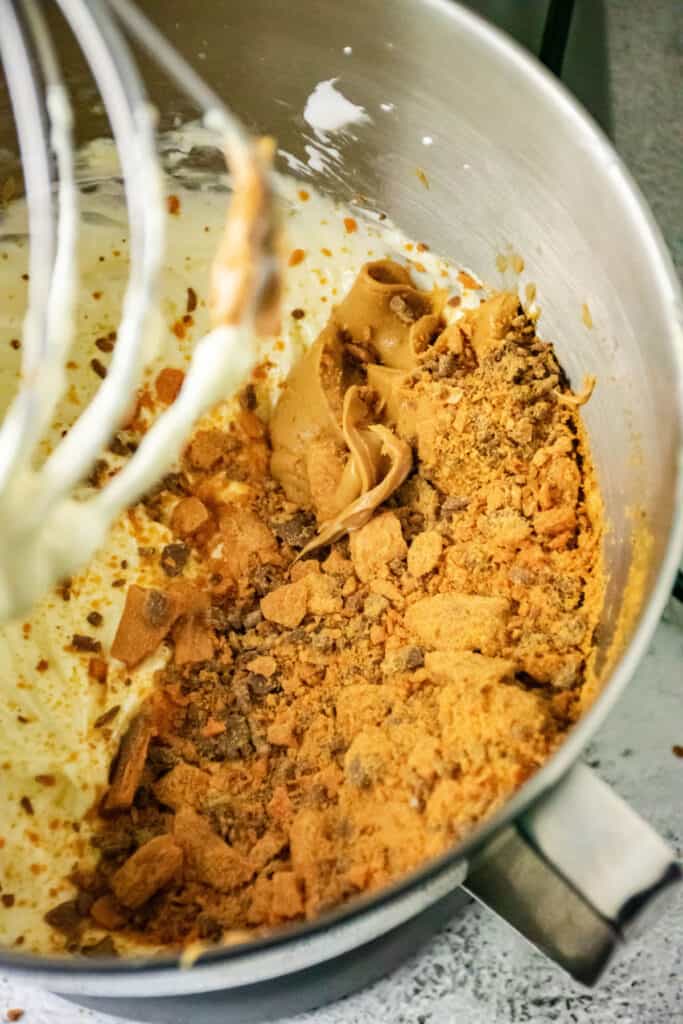 adding peanut butter and crushed butterfingers to cream cheese mixture