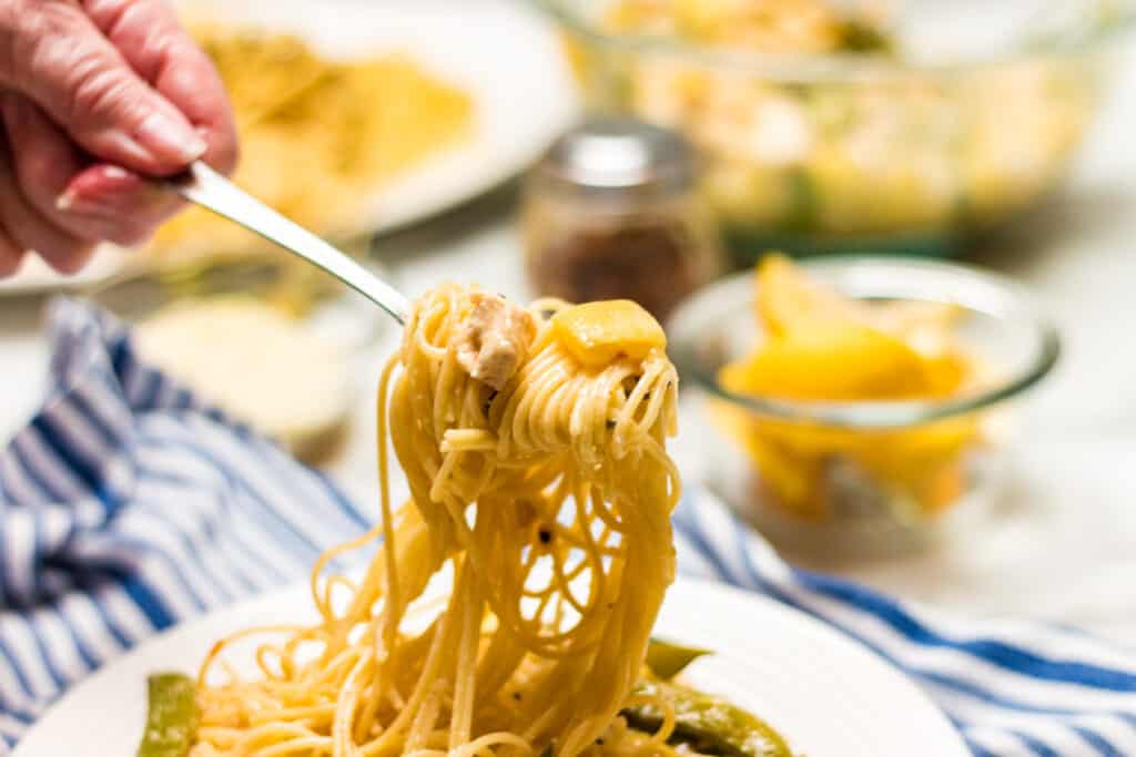 serving of lemon chicken pasta with a lifted fork