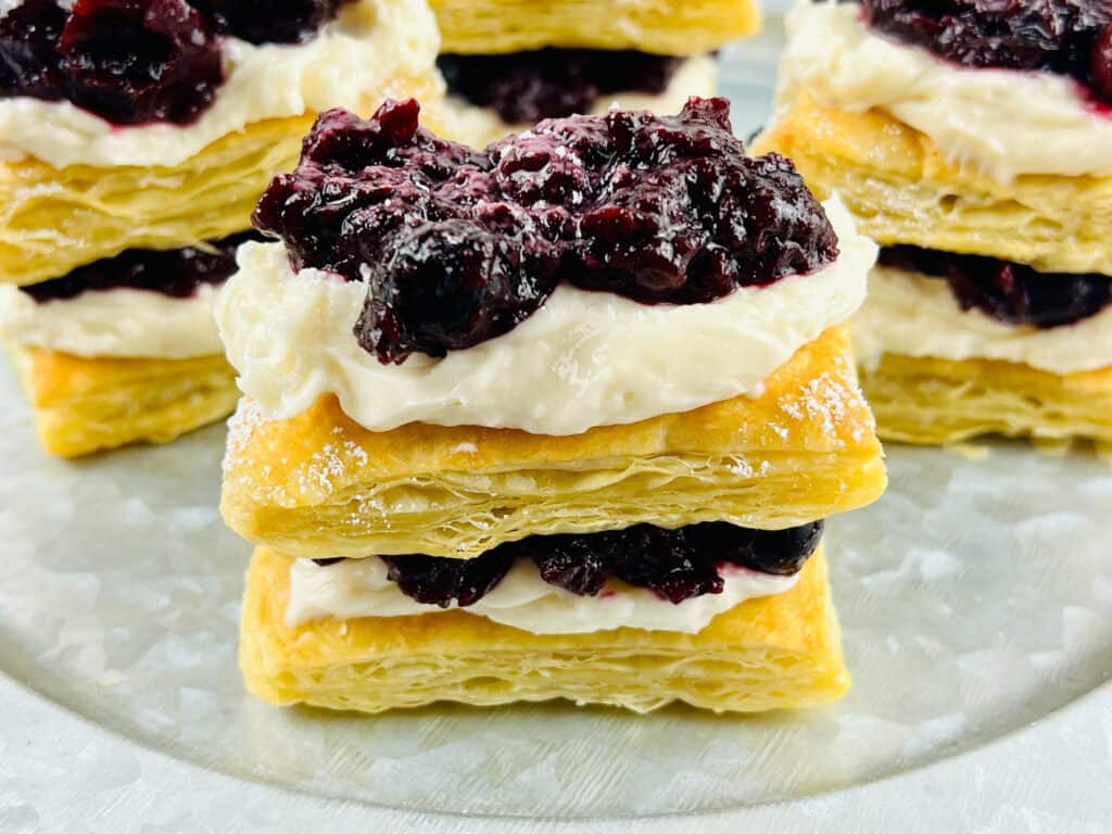 blueberry pastry on clear plate with pastries in background