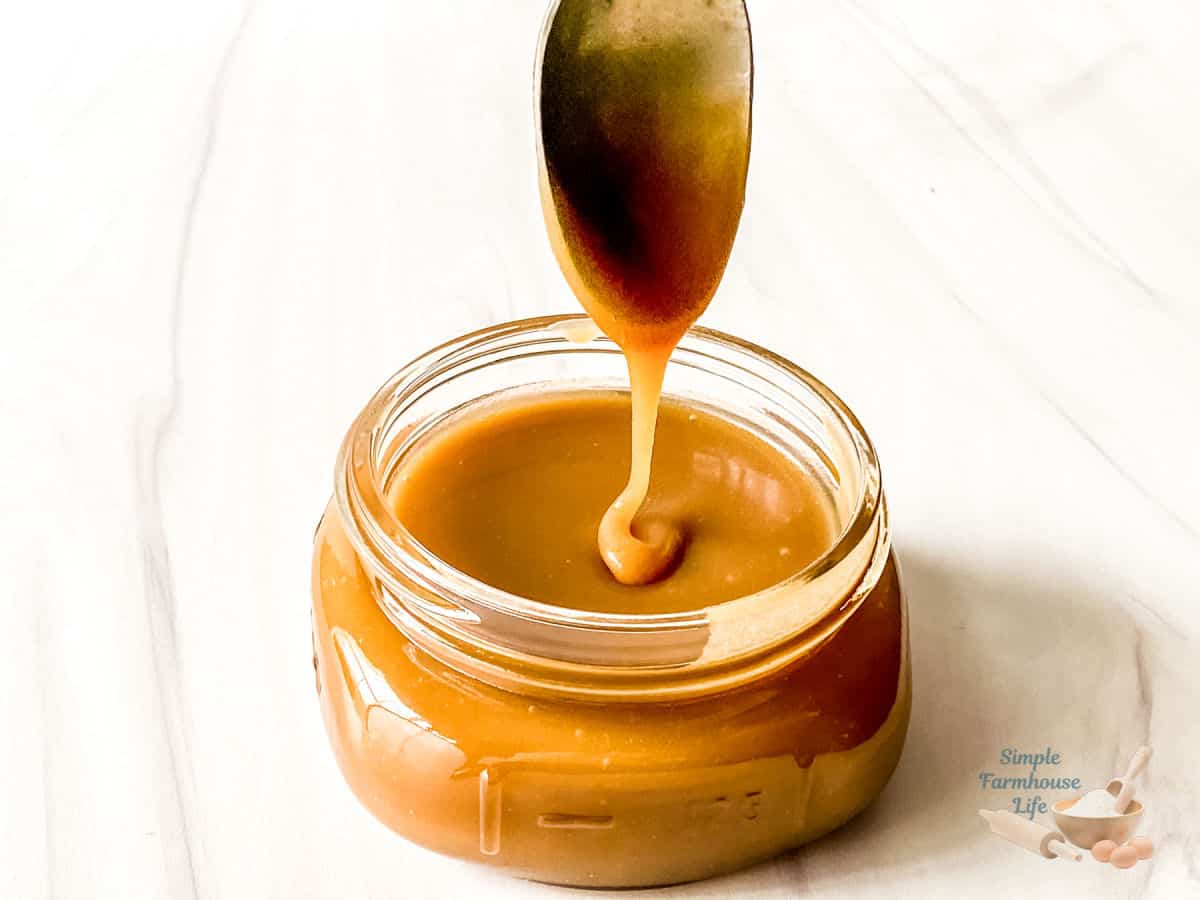 caramel topping in jar with spoon