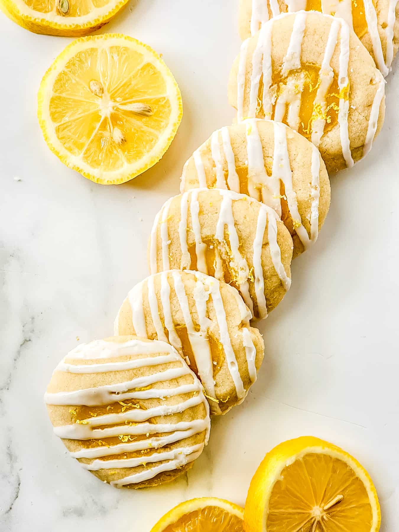 row of lemon filled shortbread cookie with slices of lemon