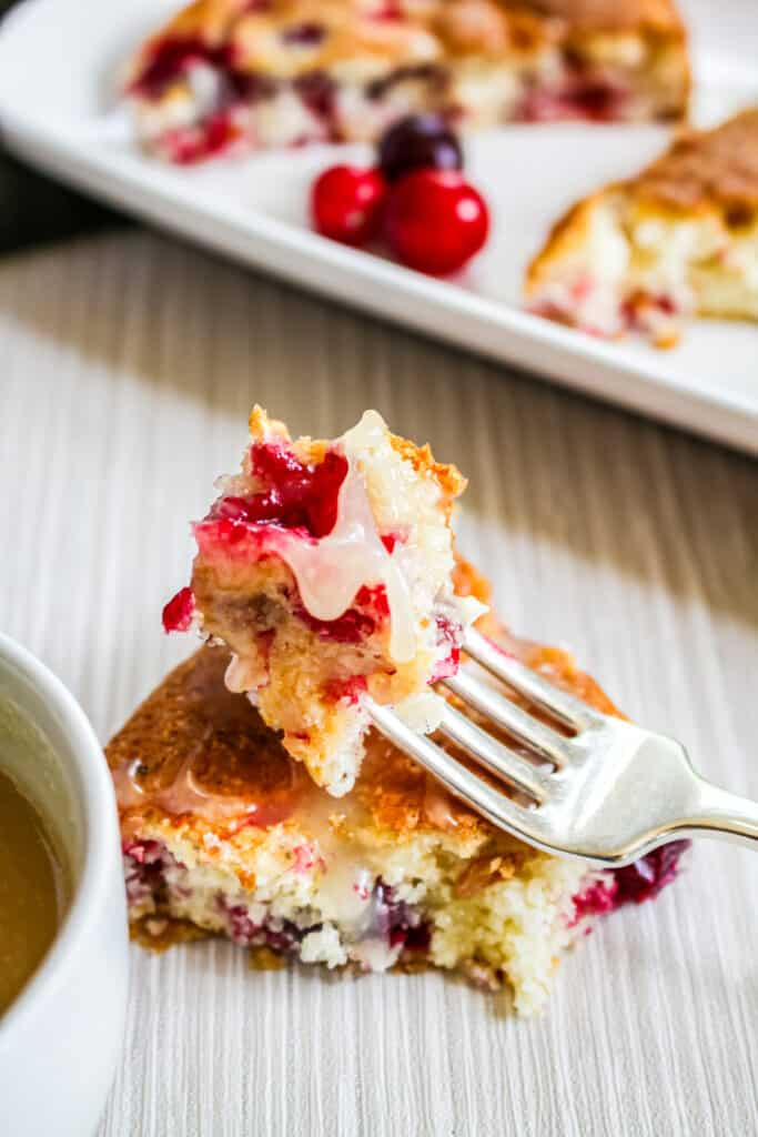 bite of cranberry cake with butter sauce.