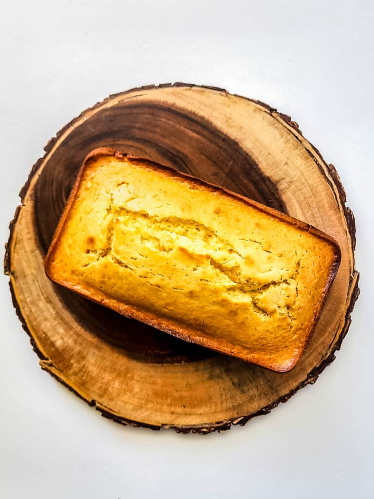 fresh baked orange loaf cake on wooden tray.
