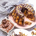 cut marble bundt cake with a slice of cake on the plate in front.